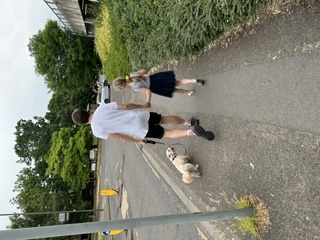 Walking the dog with a child along a leafy Bookham pavement